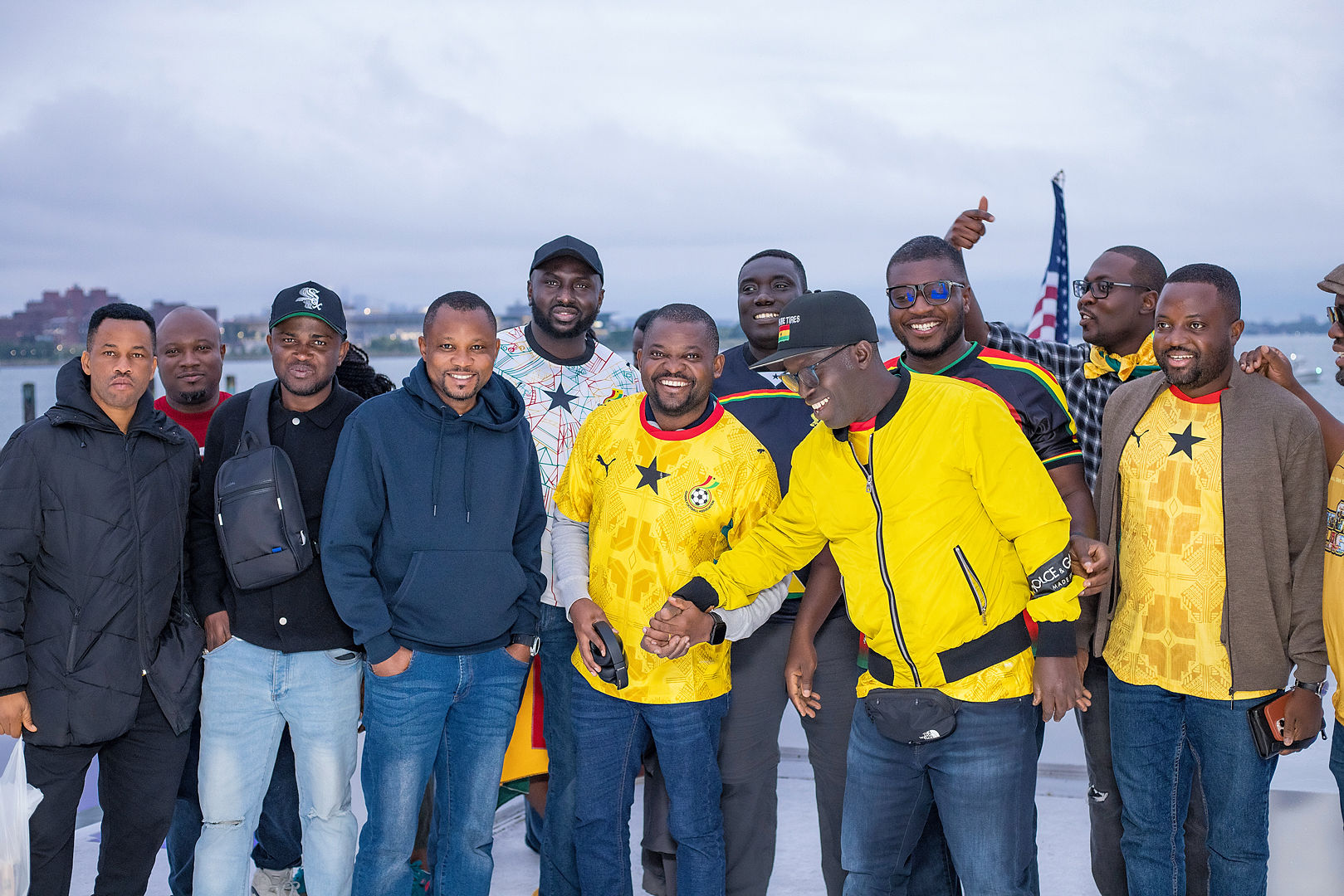 Group of Ghana fans by the waterfront at dusk
